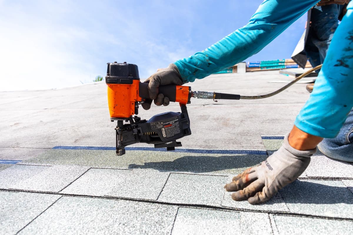 Professional roofer installing asphalt shingles